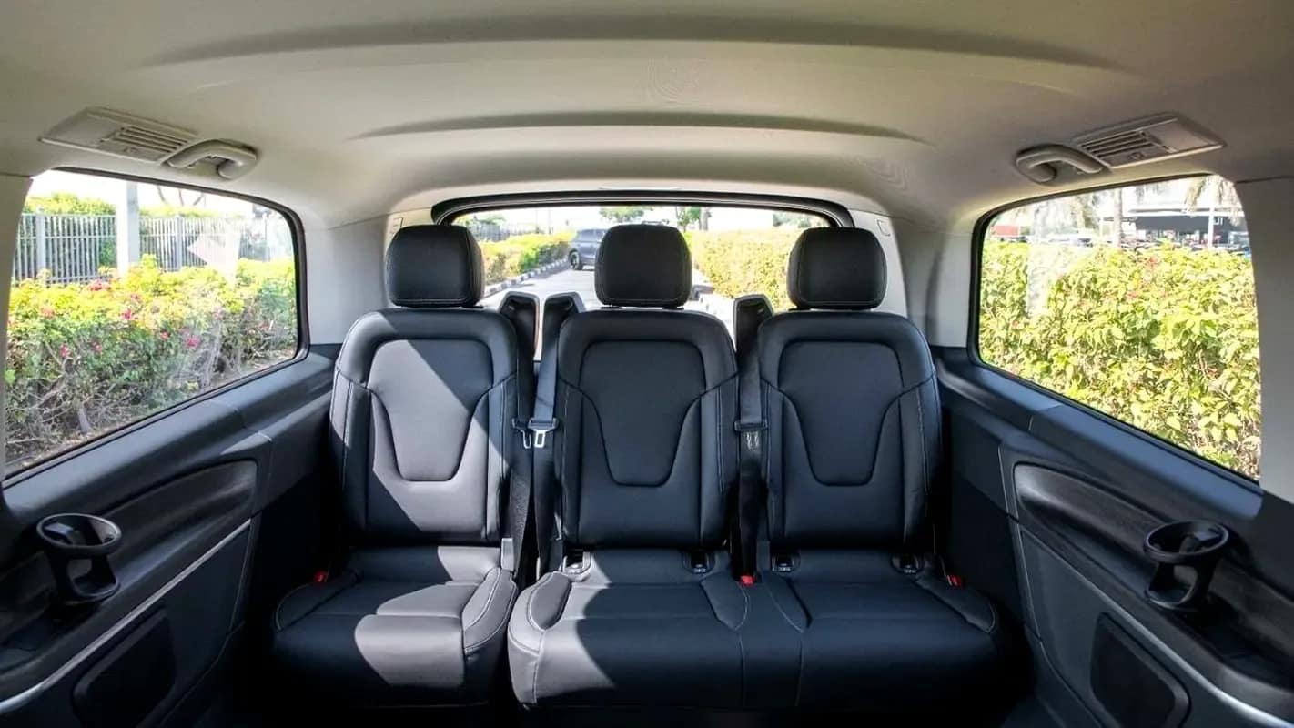 The rear cabin of a V-Class, captain's seats facing each other, city beyond the glass