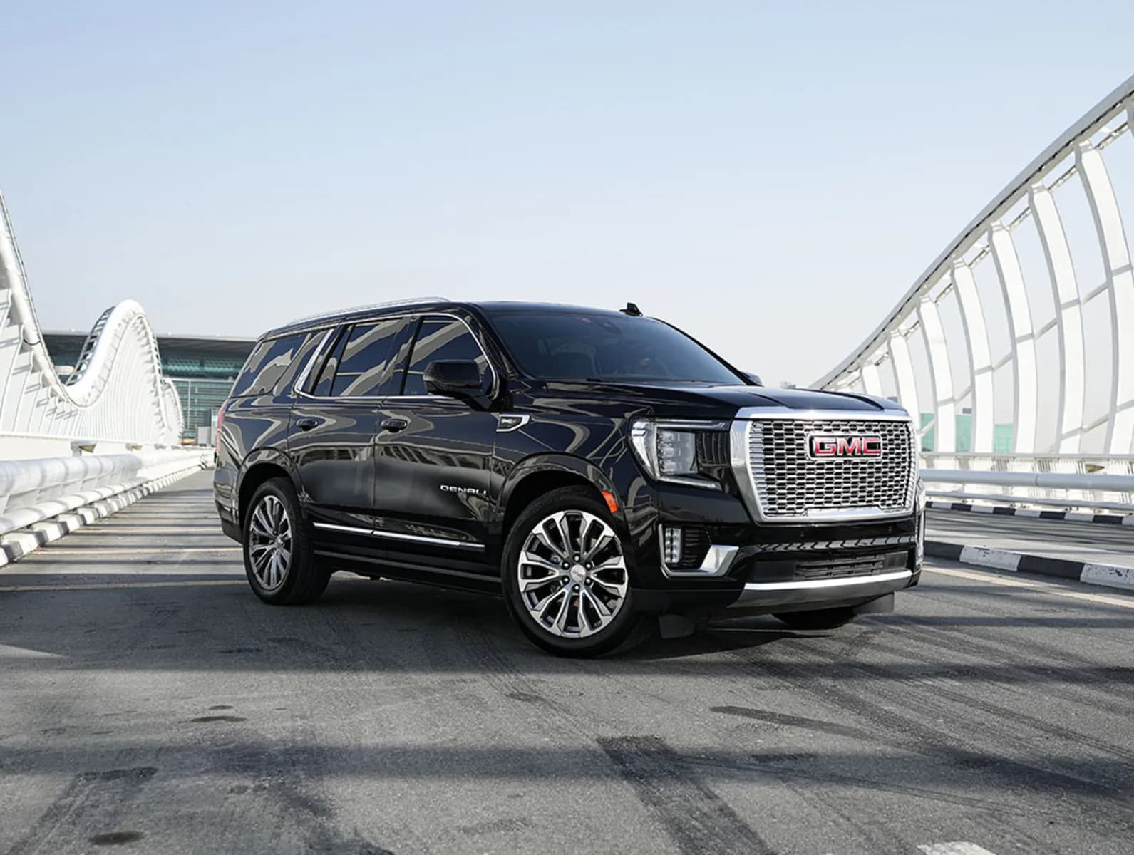 GMC Yukon Denali in black, front three-quarter on a bridge